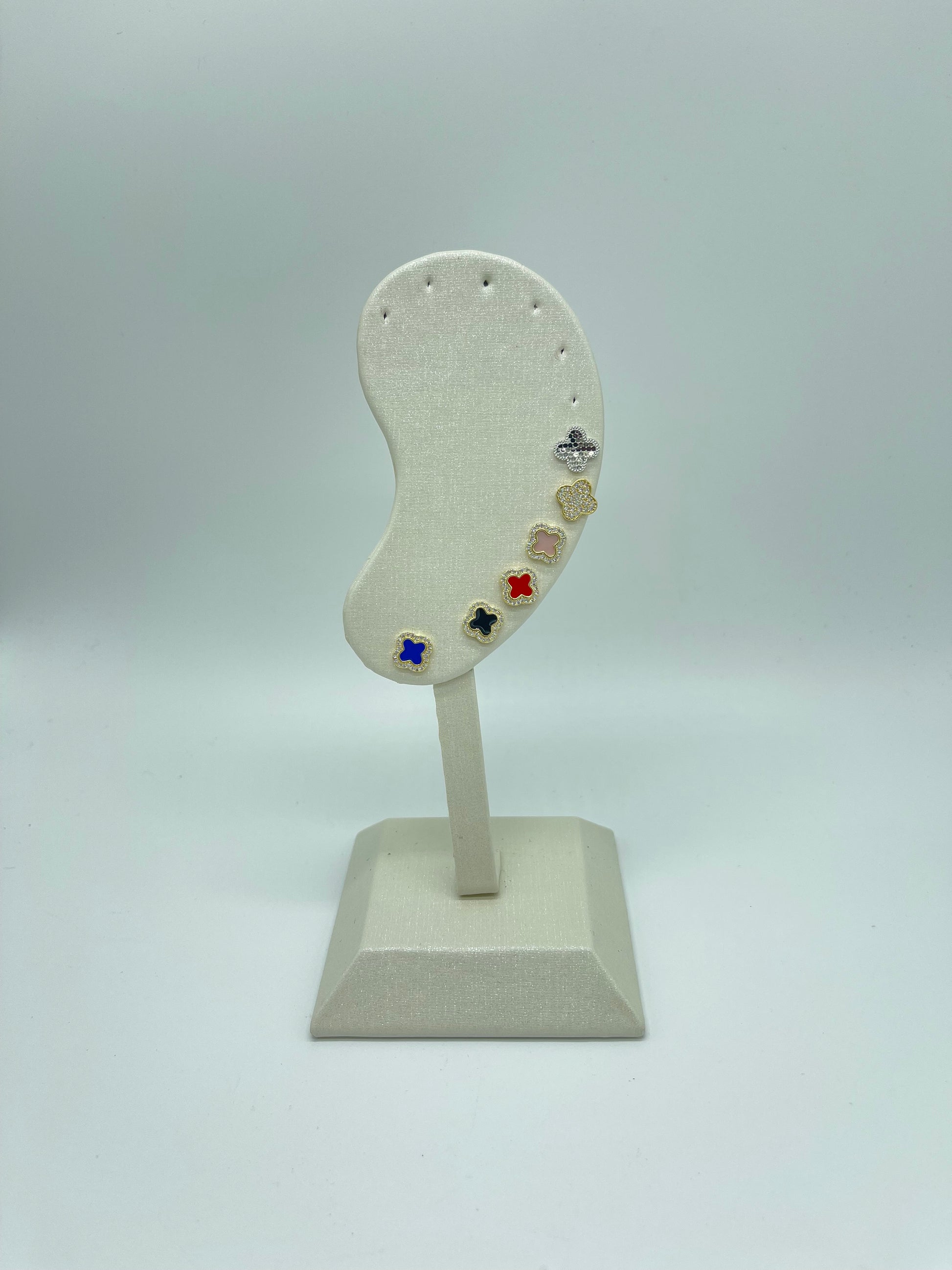 Earring stand with colorful earrings on a light gray background